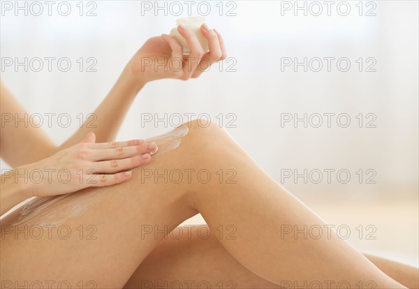 Studio shot of young woman caring for skin.