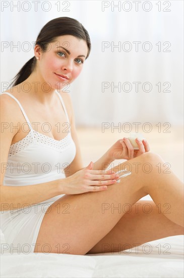 Portrait of woman applying moisturizer.