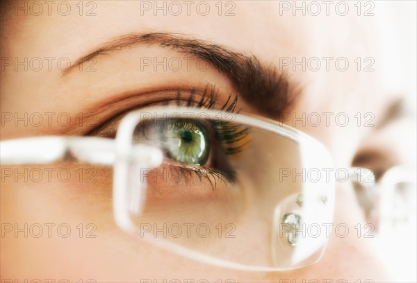 Studio close-up of woman wearing eyeglasses.