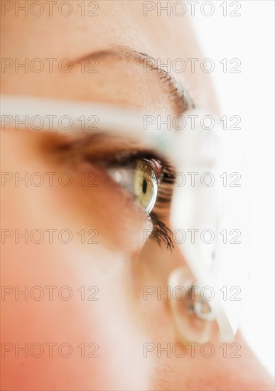 Studio close-up of woman wearing eyeglasses.