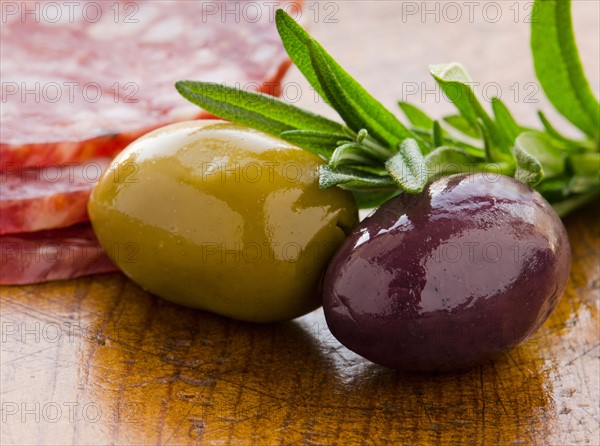 Close-up of green and black olives with rosemary, studio shot.