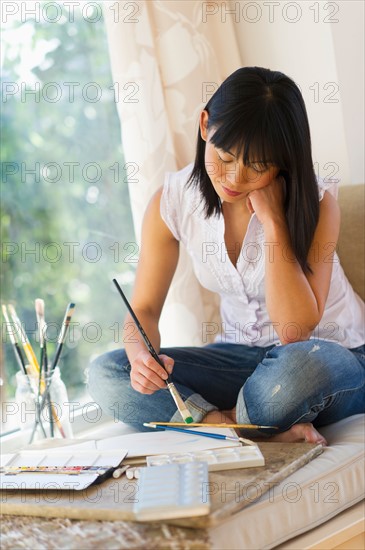 Mid adult woman painting at home.