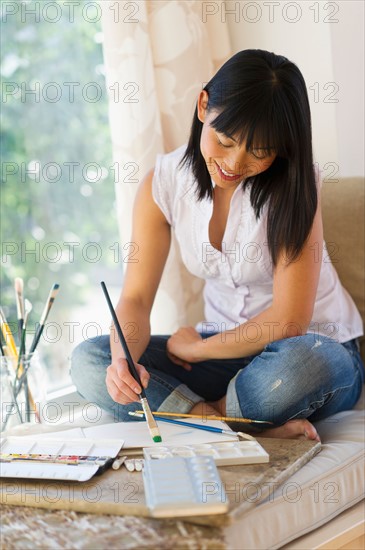 Mid adult woman painting at home.