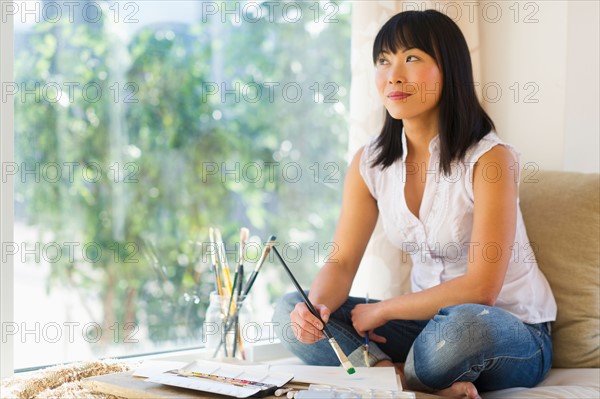 Mid adult woman painting at home.