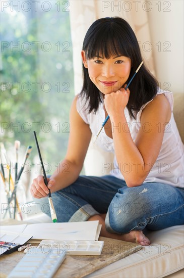 Portrait of mid adult painter at home.