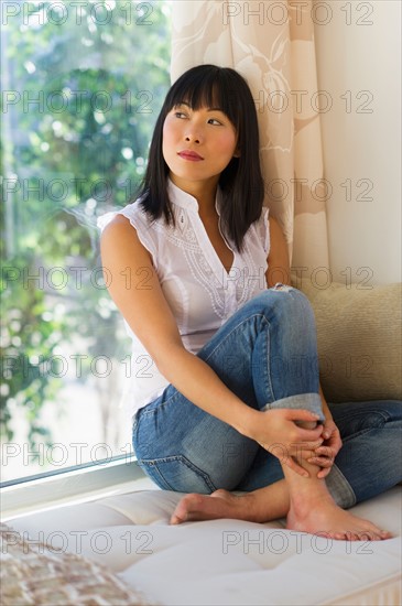 Mid adult woman looking through window.