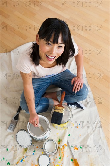 Portrait of smiling woman mixing paint.