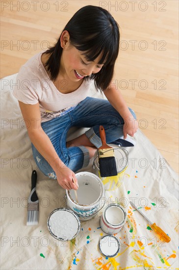 Smiling woman mixing paint.