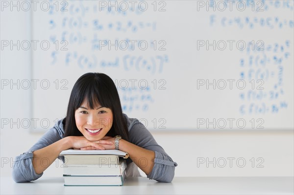 Portrait of smiling woman in front of board with equations.