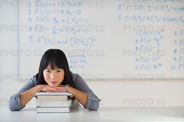 Portrait of smiling woman in front of board with equations.