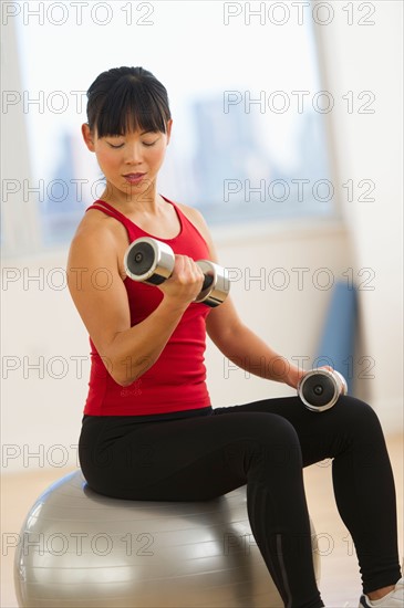 Mid adult woman exercising with dumbbells.