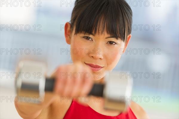 Mid adult woman exercising with dumbbells.