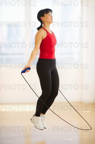 Mid adult woman training with skipping rope.