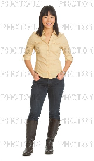 Mid adult smiling woman standing, studio shot.