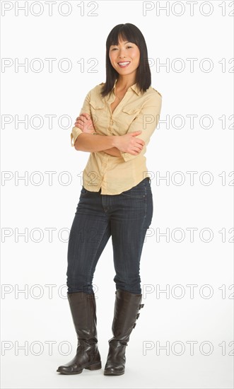 Mid adult smiling woman standing, studio shot.