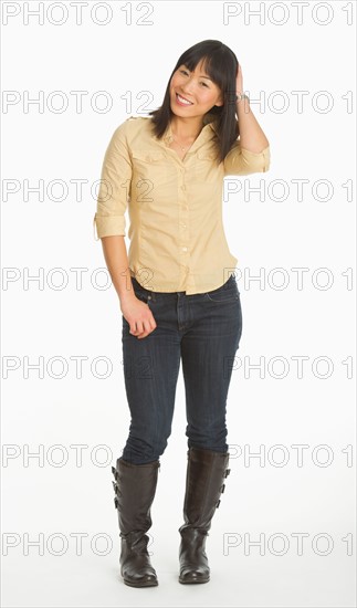 Mid adult smiling woman standing, studio shot.