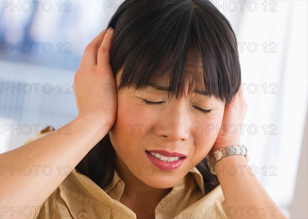 Woman covering ears.