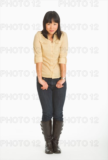 Mid adult smiling woman standing, studio shot.