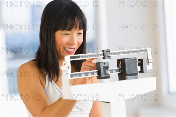 Smiling woman checking her weight.