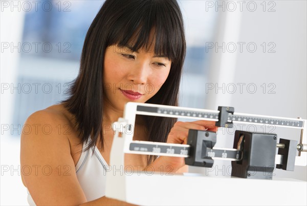 Smiling woman checking her weight.