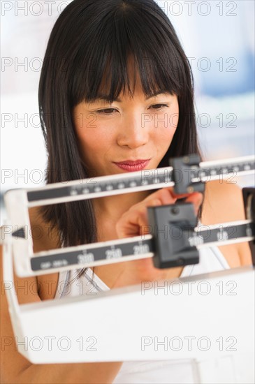 Smiling woman checking her weight.