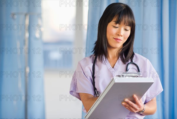 Doctor noting in medical chart of clipboard.