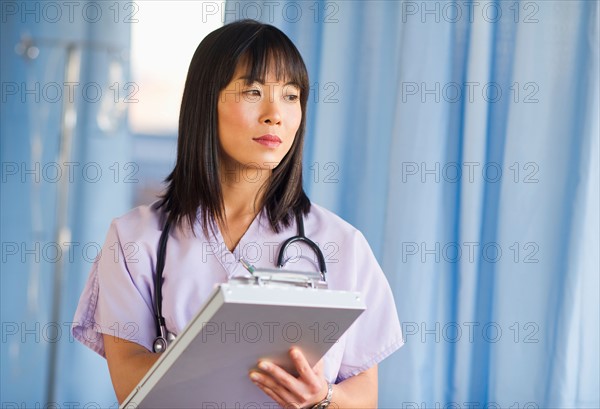 Doctor noting in medical chart of clipboard.