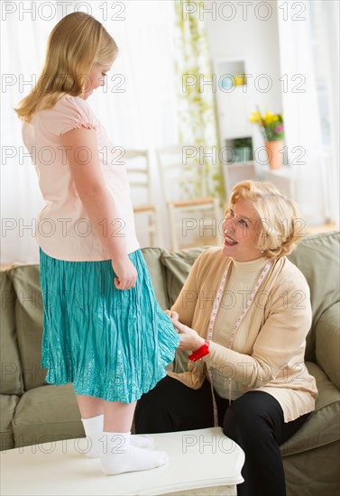 Grandmother with granddaughter (8-9) sewing together.