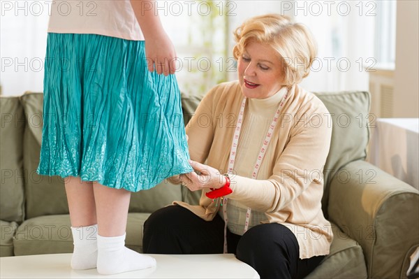 Grandmother with granddaughter (8-9) sewing together.