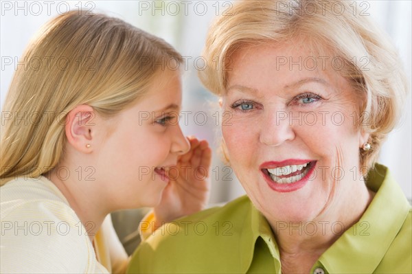 Granddaughter (8-9) whispering to her grandmother ear.