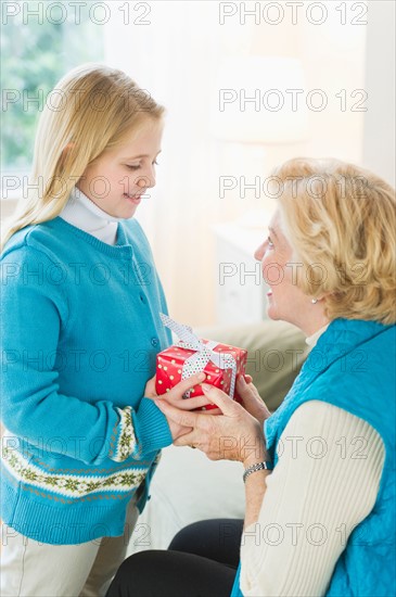 Granddaughter (8-9) receiving gift from grandmother.