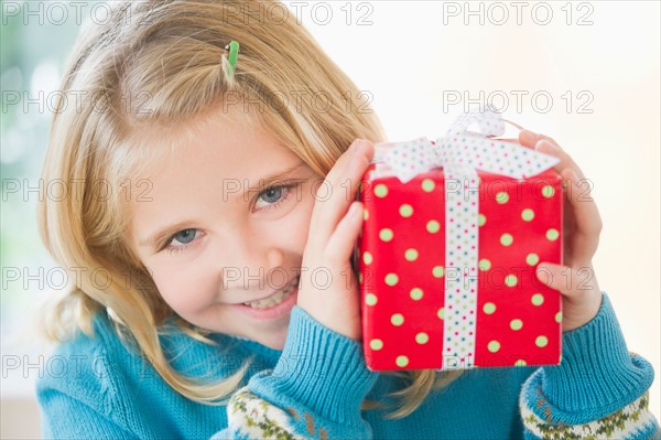Portrait of smiling girl (8-9) holding gift.