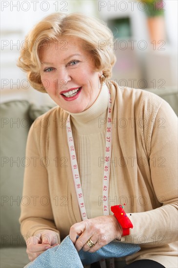 Portrait of senior woman sewing.