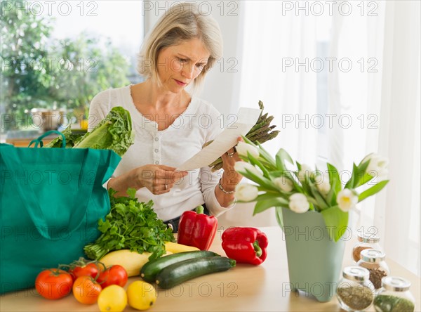 Portrait of senior woman with shopping bag in kitchen.