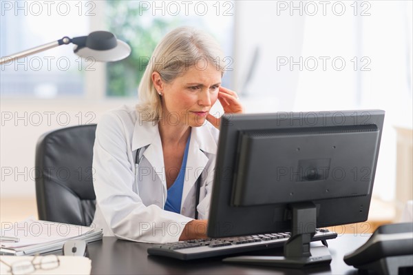 Senior female doctor working in her office.