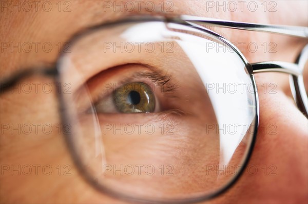 Close up of men's eye looking through glasses.