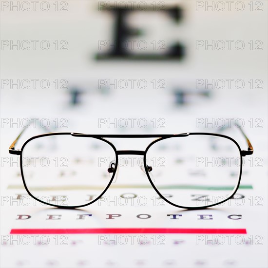 Close up of glasses on eye chart, studio shot.