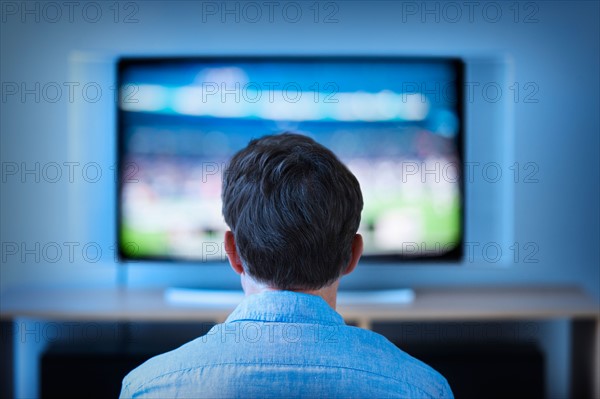 Man watching tv in living room.