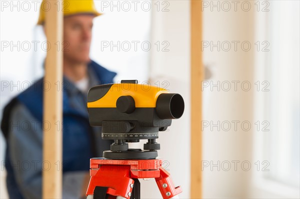 Construction worker with theodolite.