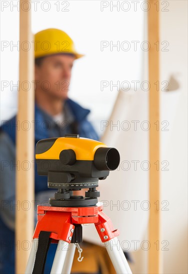 Construction worker with theodolite.