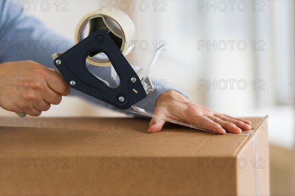 Man's hands packing delivery.