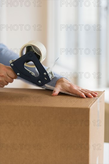 Man's hands packing delivery.