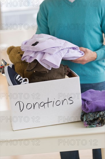 Man packing clothes for donation.