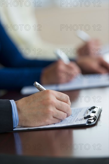 Close up of man's hands filling application form.