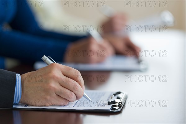 Close up of man's hands filling application form.