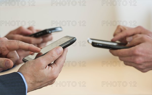 Close up of businessmen's hands holding PDA.