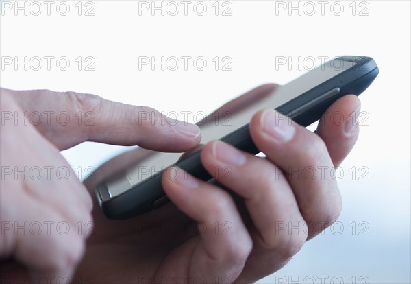 Close up of businessman's hands holding PDA.