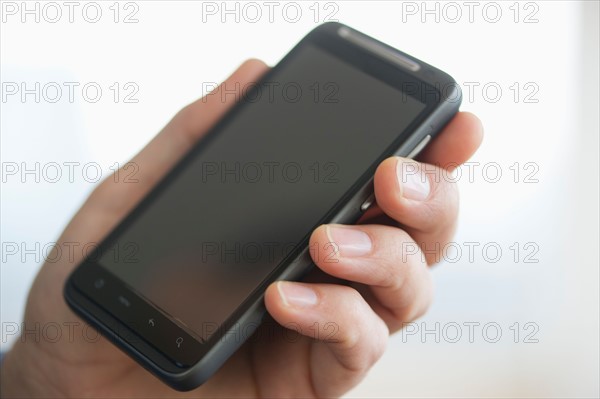 Close up of businessman's hands holding PDA.