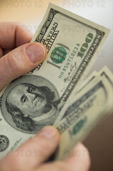 Close up of man's hands counting dollar banknotes.
