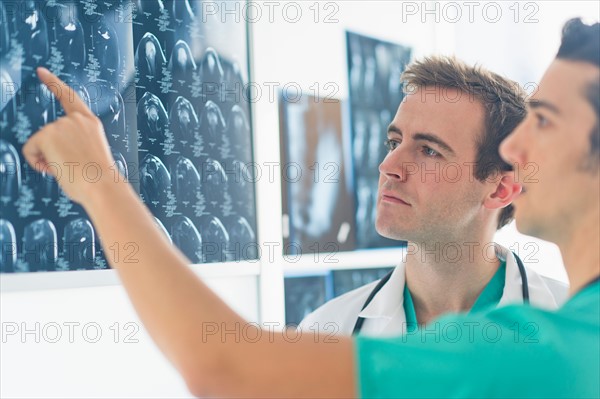 Two male doctors discussing x-ray images.